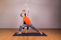 Yoga instructor guiding student perform extended side angle pose