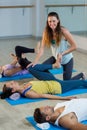 Yoga instructor helping student with leg flexes Royalty Free Stock Photo