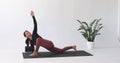 Yoga instructor performs Parivritta Prishthasana exercise, twisted lizard pose