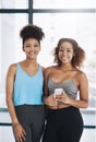 Yoga keeps us smiling. Cropped portrait of two young women looking at a cellphone after yoga class. Royalty Free Stock Photo