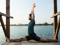 Yoga master doing monkey pose near water Royalty Free Stock Photo