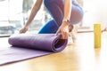 Yoga Mat. Closeup womans hands is rolling TPE rubber exercise fitness yoga mat on the floor at sport club