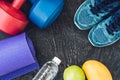 Yoga mat, sport shoes, dumbbells and bottle of water on blue background. Concept healthy lifestyle, sport and diet. Sport equipmen Royalty Free Stock Photo