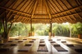 Yoga mat in a tropical garden with bamboo roof and wooden floor