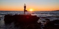 Yoga meditation. Pilates and active lifestyle concept. Fit female standing in yoga position. Sunset over sea landscape. Royalty Free Stock Photo