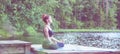 Yoga meditation by Young yogi girl on the pier of a beautiful lake. Concept of healthy life and natural balance . Panoramic