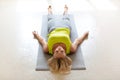 Yoga nidra practice. Caucasian adult woman lying on the floor in shavasana in the loft studio indoor, top front view