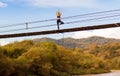 Calm woman doing yoga balance exercises. Yoga meditation on bridge over river with mountains background. Concept of Royalty Free Stock Photo