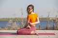Yoga outdoor. Happy woman doing yoga exercises, meditate in the park. Yoga meditation in nature. Concept of healthy lifestyle and Royalty Free Stock Photo