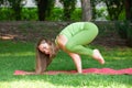 Yoga outdoor. Happy woman doing yoga exercises, meditate in the park. Pretty woman practicing yoga on the grass Royalty Free Stock Photo