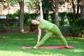 Yoga outdoor. Happy woman doing yoga exercises, meditate in the park. Pretty woman practicing yoga on the grass Royalty Free Stock Photo