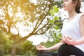 Yoga outdoors in public park. Asian woman sits in lotus position Royalty Free Stock Photo