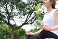 Yoga outdoors in public park. Asian woman sits in lotus position Royalty Free Stock Photo