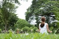 Yoga outdoors in public park. Asian woman sits in lotus position Royalty Free Stock Photo