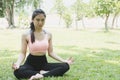 Yoga outdoors in summer park. young woman sits in lotus position Royalty Free Stock Photo