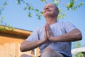 Yoga at park. Senior man with mustache with namaste sitting.Concept of calm and meditation. Royalty Free Stock Photo