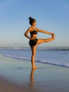 Yoga practice on the beach. Utthita Hasta Padangusthasana, Extended Hand-to-Big-Toe Pose. Standing balancing asana. Fit body. Royalty Free Stock Photo