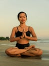 Yoga retreat. Asian woman practicing Lotus pose. Padmasana. Hands in namaste mudra. Closed eyes. Healthy lifestyle. Yoga on the Royalty Free Stock Photo