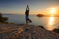 Yoga by the Sea at sunrise - Tree Pose Vrksasana Royalty Free Stock Photo