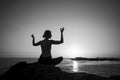 Yoga silhouette female lotus pose on the ocean during a lovely sunset. Royalty Free Stock Photo