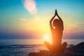 Yoga silhouette. Meditation fitness woman on the ocean during amazing sunset.