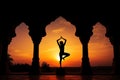 Yoga silhouette in old temple at sunset sky background. Royalty Free Stock Photo