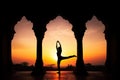 Yoga silhouette in old temple at sunset sky background. Royalty Free Stock Photo