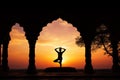 Yoga silhouette in old temple at sunset sky background. Royalty Free Stock Photo