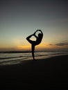 Yoga silhouette. Sunset beach yoga. Slim woman practicing standing asana Natarajasana, Lord of the Dance Pose. Balancing, back Royalty Free Stock Photo