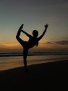 Yoga silhouette. Sunset beach yoga. Slim woman practicing standing asana Natarajasana, Lord of the Dance Pose. Balancing, back Royalty Free Stock Photo