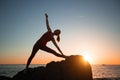 Yoga silhouette young woman doing fitness exercises on the beach at sunset Royalty Free Stock Photo