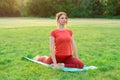 Yoga and stretching exercise at sunrise in nature. Young beautiful slender girl on a yoga mat practices yoga in a pigeon pose.