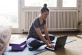 Yoga student doing online classes on laptop at home