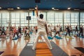 Yoga teacher and active people performing some simple asanas together, training in sport center class