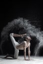 A yoga teacher sits in a sukhasana on a black background. Royalty Free Stock Photo