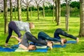 Yoga teacher helping students with halasana