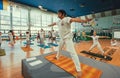 Yoga teacher showing asana for active people in sport studio, training class