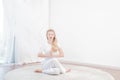 Beautiful woman is practicing yoga at home, girl doing Gomukasana exercise, sitting in Cow Face pose Royalty Free Stock Photo