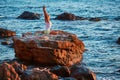 Yoga time and pilates concept, copy space. Lady stretching sitting on stone. Beautiful sea view. Training on fresh air. Royalty Free Stock Photo