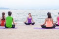 Yoga training class at sea beach in evening sunset ,Group of people doing lotus poses with relax emotion Royalty Free Stock Photo
