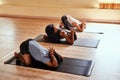 Yoga, where inner strength meets outer strength. a group of young men and women practicing the childs pose during a yoga Royalty Free Stock Photo