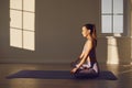 Yoga woman in yoga class practices yoga sitting on the floor in lotus position in a room with sunny windows. Royalty Free Stock Photo