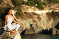 Yoga woman meditating at sunset or sunrise in black sea Crimea.