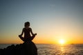 Yoga woman on the ocean coast during sunset Royalty Free Stock Photo