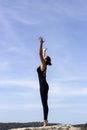 Yoga woman poses on beach near sea and rocks