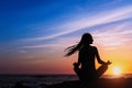 Yoga woman silhouette meditation on the ocean during amazing sunset. Royalty Free Stock Photo