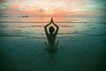 Yoga woman silhouette on the sea beach at amazing sunset. Meditation and healthy lifestyle. Royalty Free Stock Photo