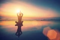 Yoga woman sitting in lotus pose on the beach with reflection in water. Royalty Free Stock Photo