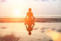 Yoga woman sitting in lotus pose on the beach during sunset Royalty Free Stock Photo