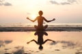 Yoga woman sitting in lotus pose on the beach during sunset, with reflection in water. Royalty Free Stock Photo